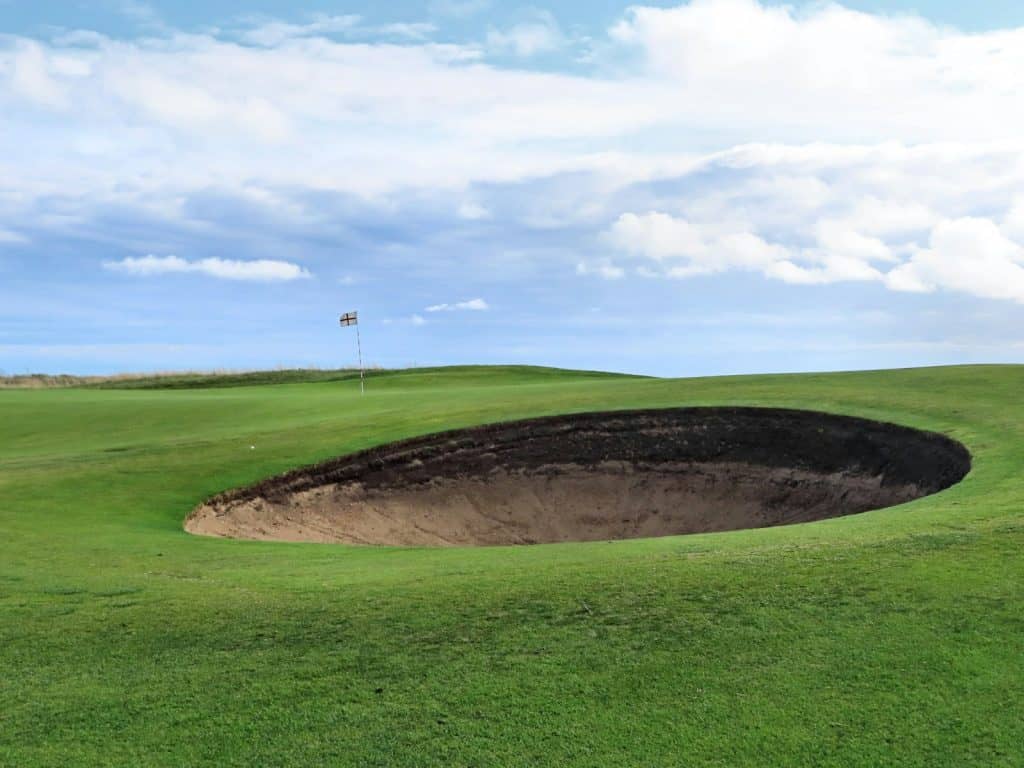 A green golf course with a hole in the middle